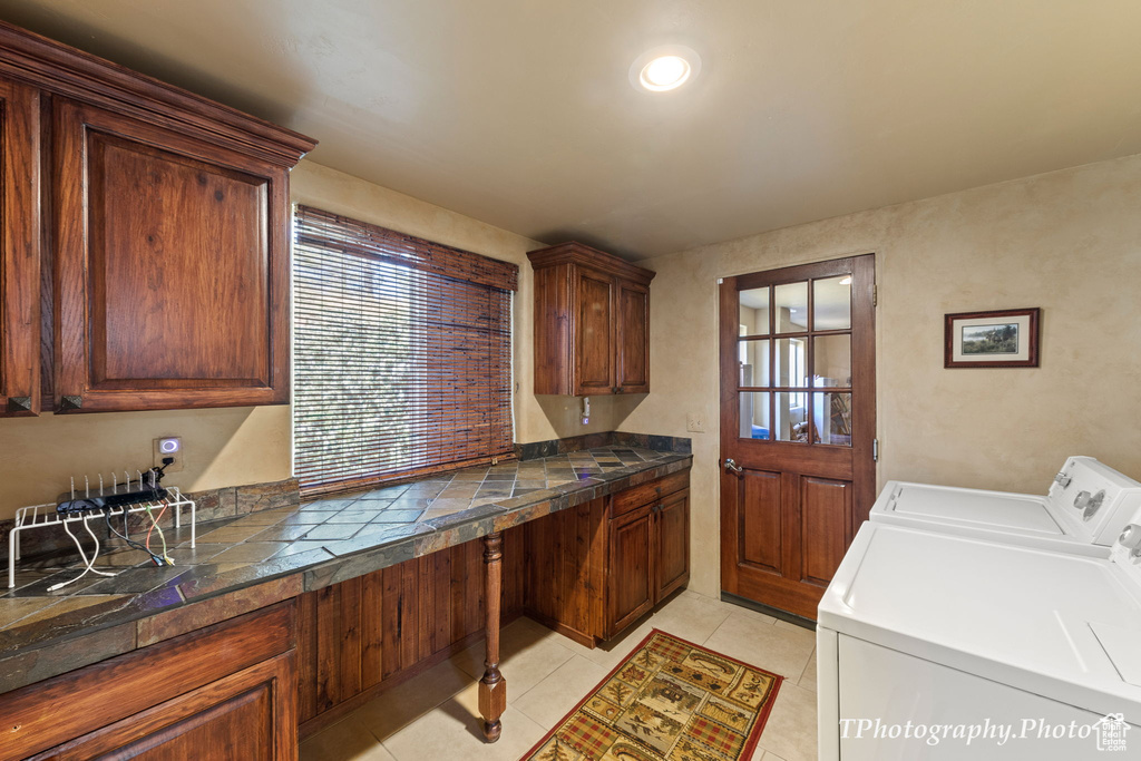Laundry area featuring cabinets, light tile floors, and separate washer and dryer