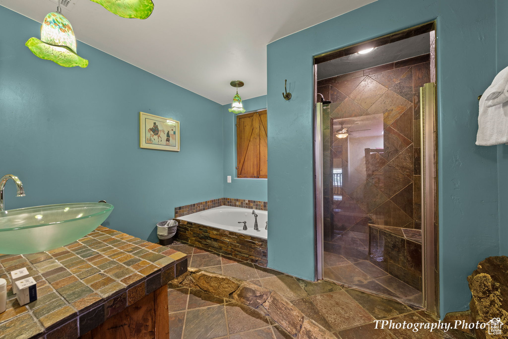 Bathroom featuring separate shower and tub, tile flooring, and vanity