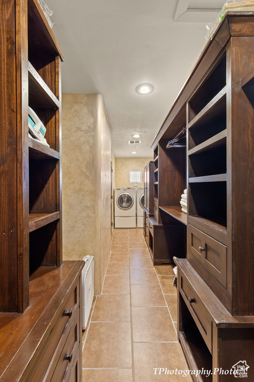 Walk in closet with washer and dryer and light tile floors