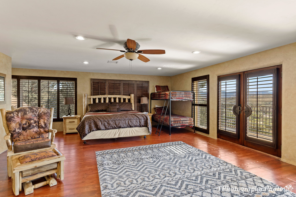 Bedroom featuring access to exterior, dark wood-type flooring, and ceiling fan