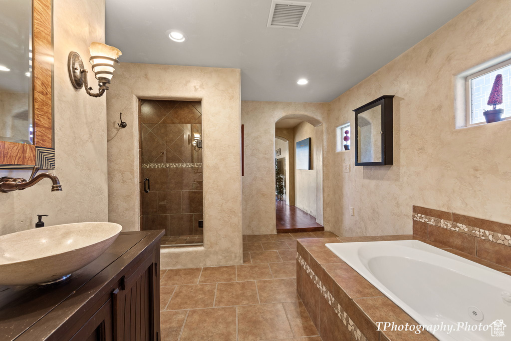 Bathroom with hardwood / wood-style floors, vanity, and separate shower and tub