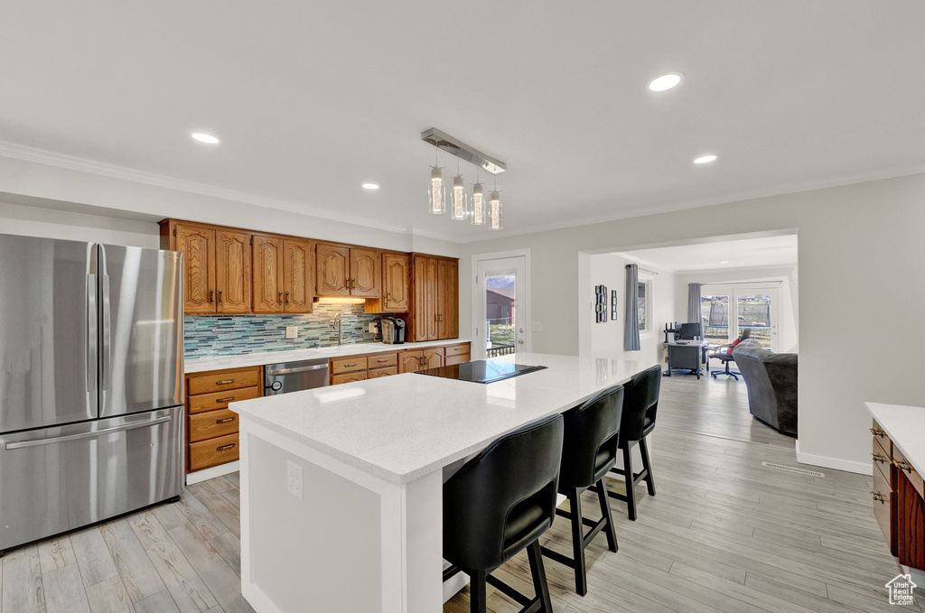 Kitchen with plenty of natural light, backsplash, stainless steel appliances, and a center island