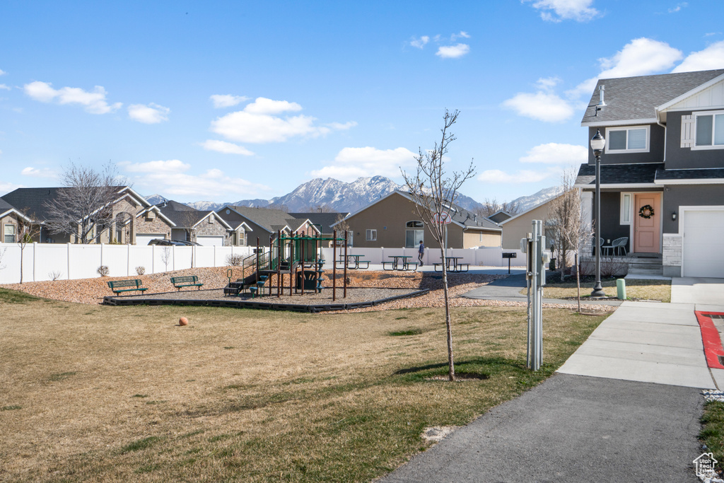 Exterior space with a yard, a mountain view, and a playground