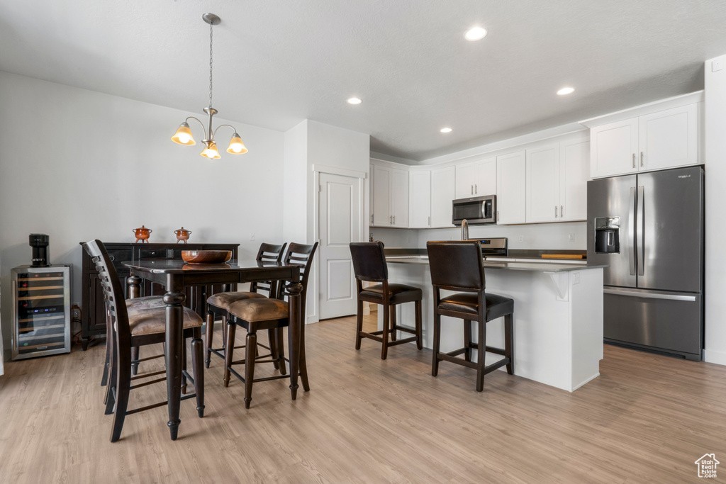 Kitchen featuring a chandelier, stainless steel appliances, and light hardwood / wood-style floors