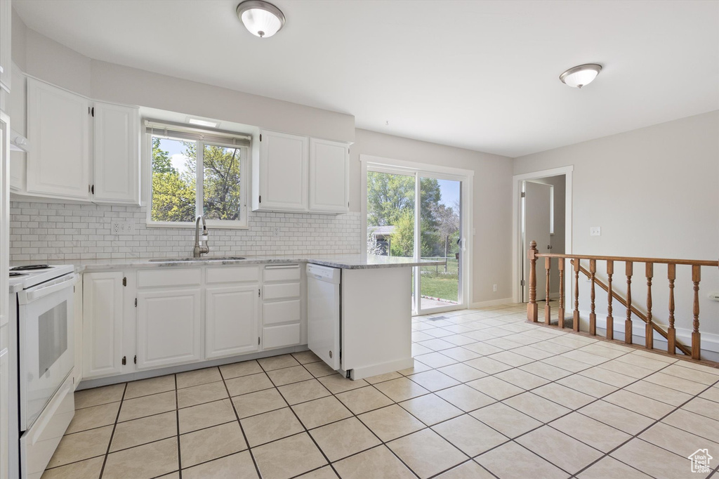 Kitchen featuring backsplash, dishwasher, range, white cabinetry, and sink