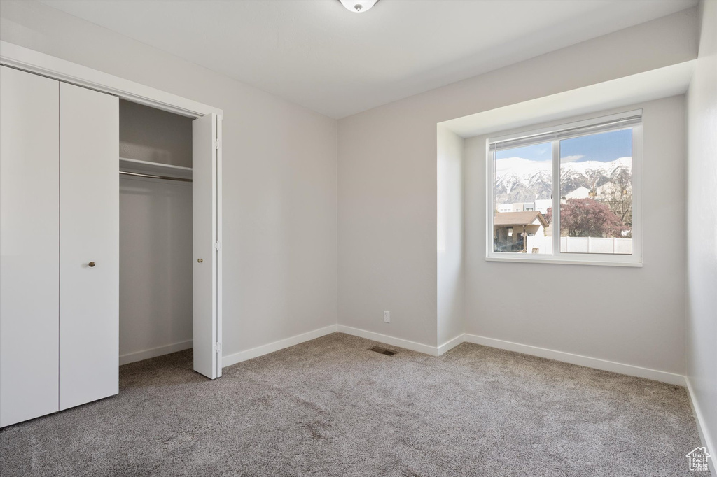 Unfurnished bedroom with a closet and carpet