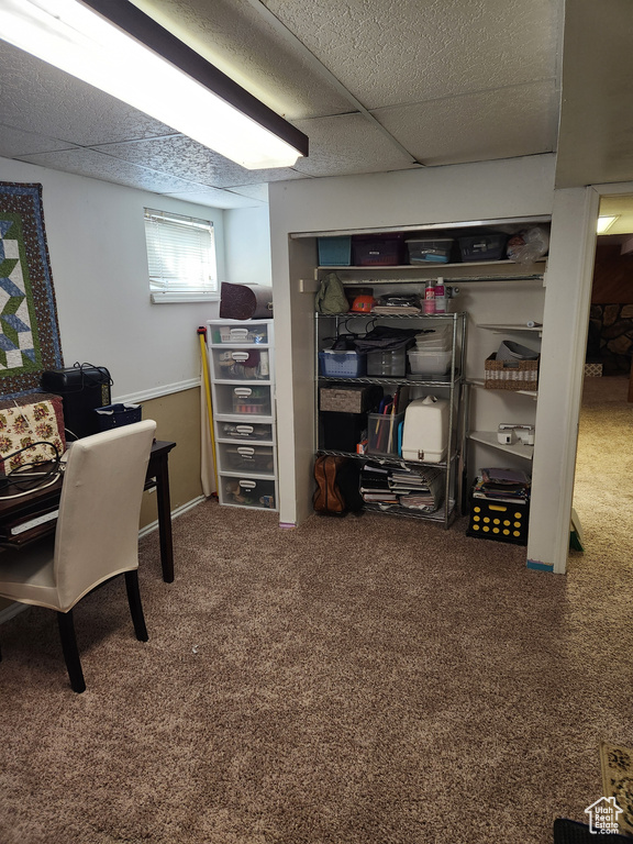 Carpeted home office featuring a drop ceiling