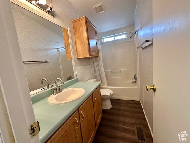 Full bathroom featuring vanity, wood-type flooring, shower / bathtub combination, and toilet