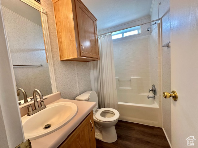 Full bathroom with vanity, crown molding, toilet, hardwood / wood-style floors, and shower / bath combination with curtain