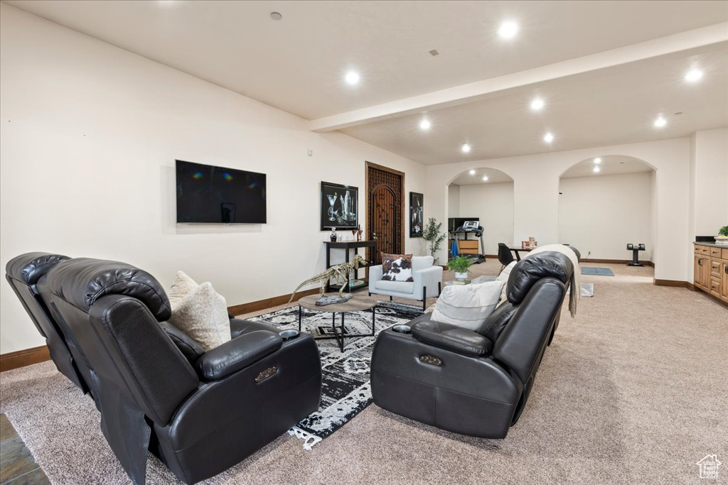 Living room featuring beamed ceiling and carpet
