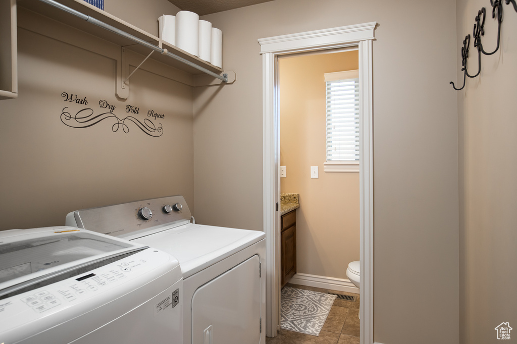 Washroom featuring independent washer and dryer and light tile floors