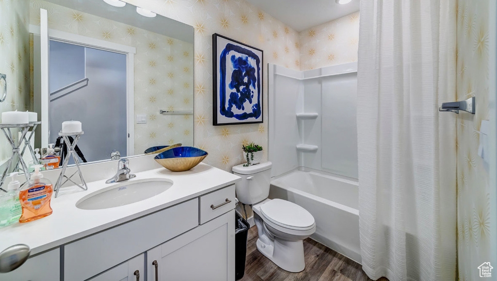 Full bathroom with shower / bath combo, hardwood / wood-style floors, vanity, and toilet