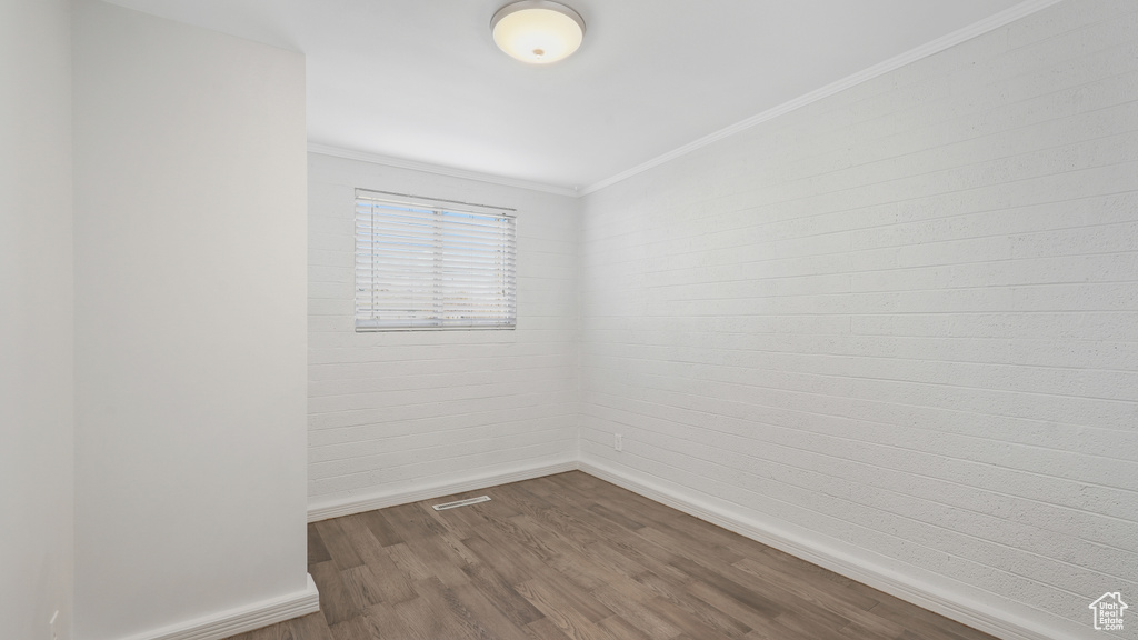 Unfurnished room with crown molding and dark hardwood / wood-style floors