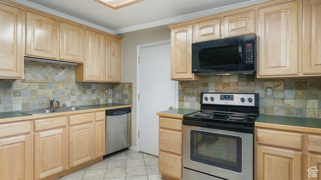 Kitchen featuring backsplash, sink, light tile flooring, and stainless steel appliances