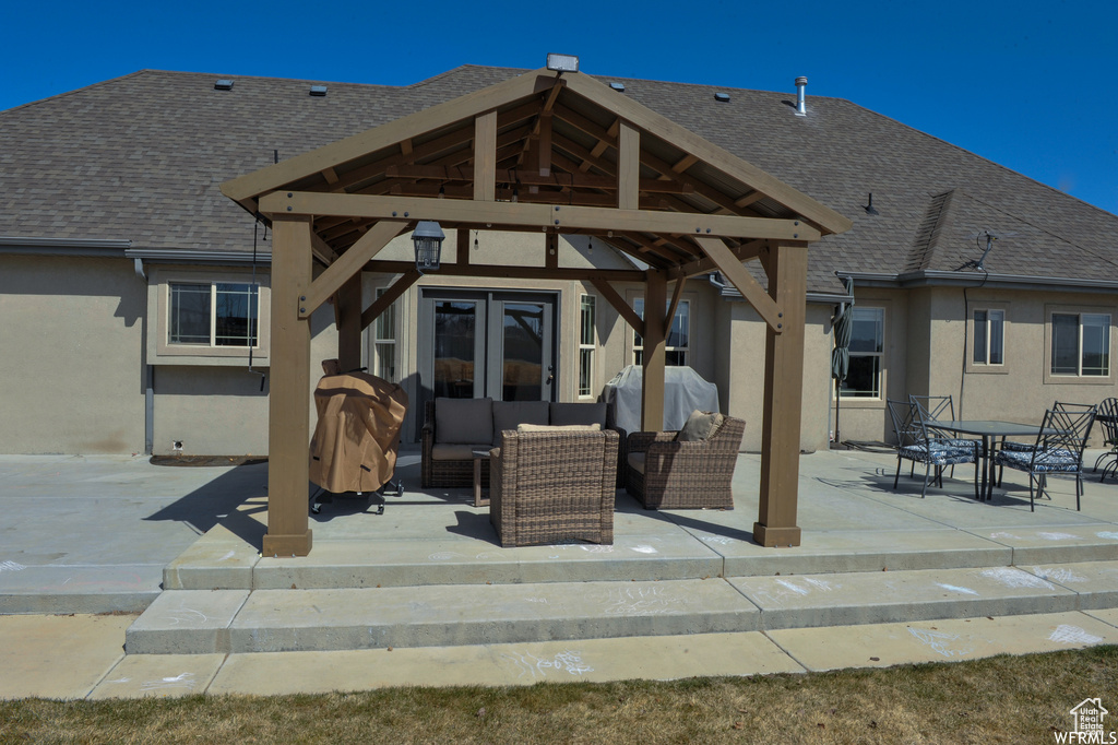 Rear view of property with an outdoor living space, a patio area, and a gazebo