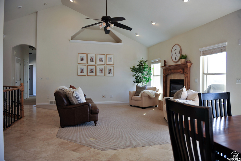 Living room featuring a wealth of natural light, light tile floors, high vaulted ceiling, and ceiling fan