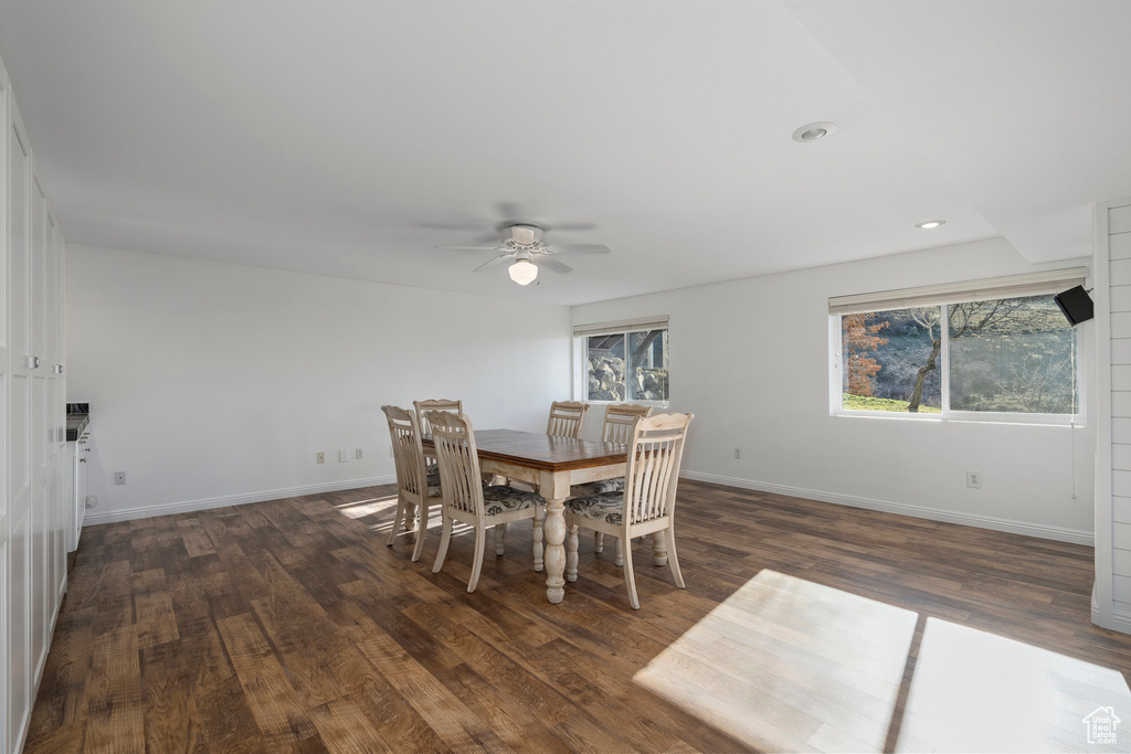 Dining area with dark wood-type flooring and ceiling fan