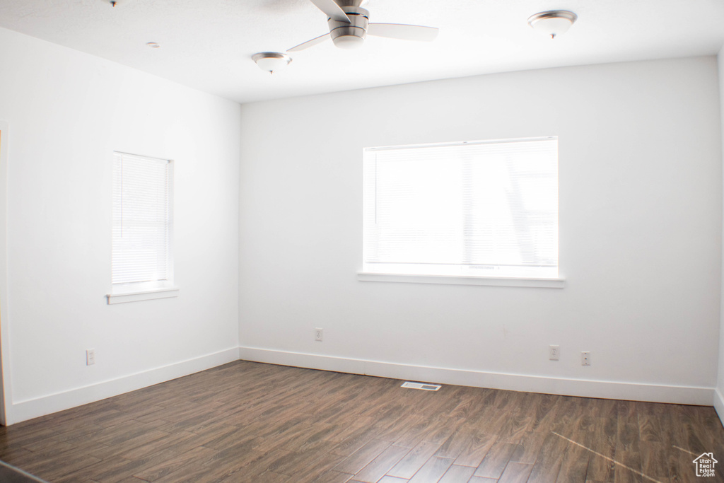 Unfurnished room featuring ceiling fan and dark hardwood / wood-style floors
