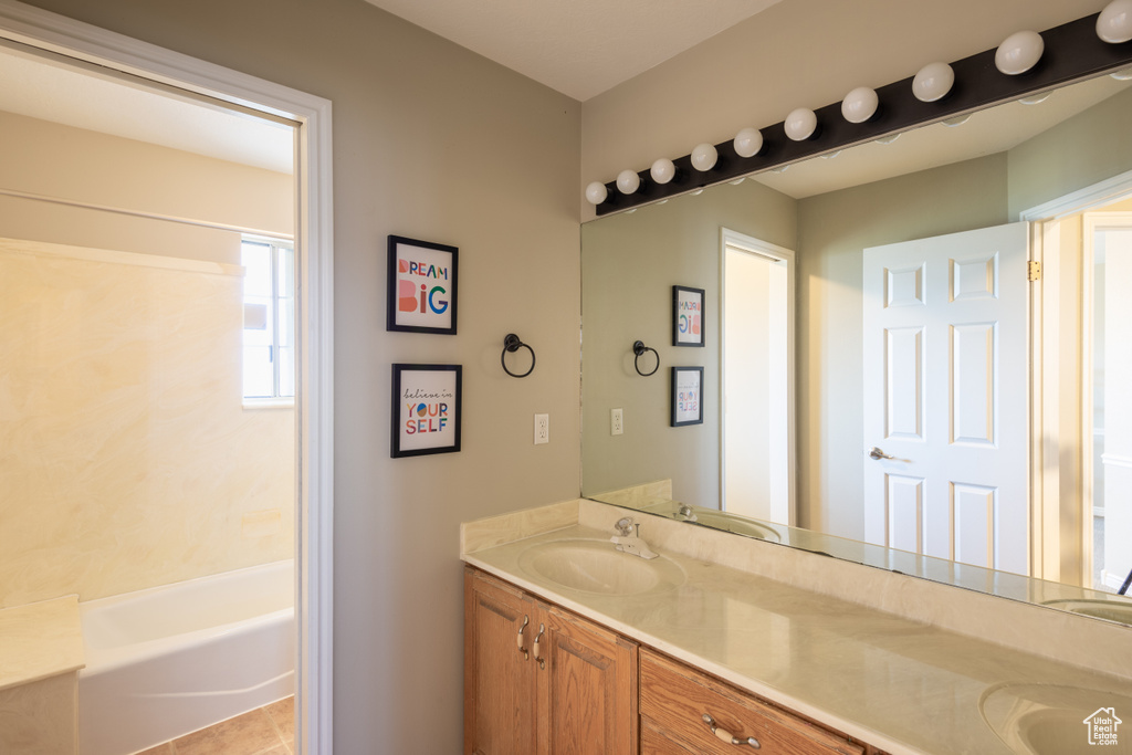Bathroom featuring large vanity, tile flooring, bathtub / shower combination, and double sink