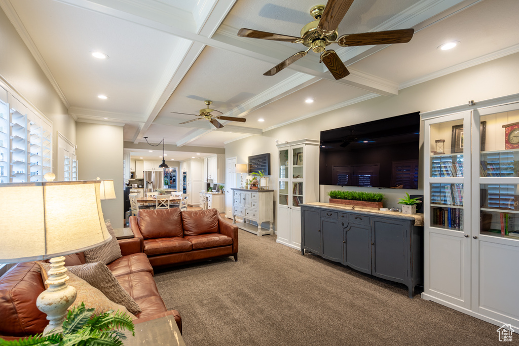 Carpeted living room featuring beam ceiling and ceiling fan