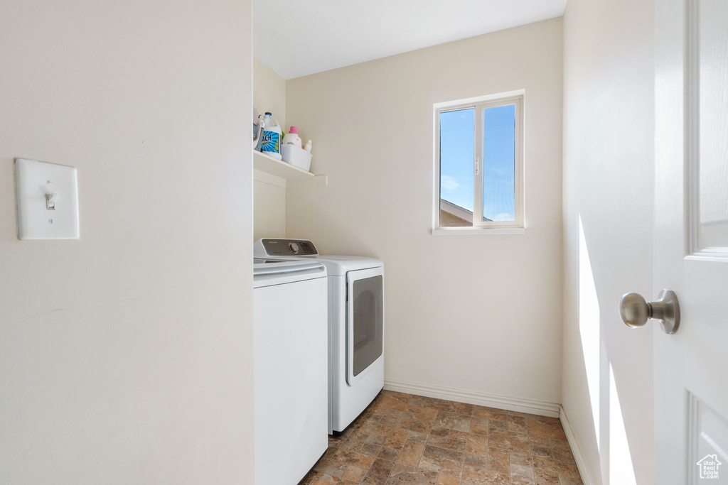 Laundry room featuring washing machine and clothes dryer and tile floors