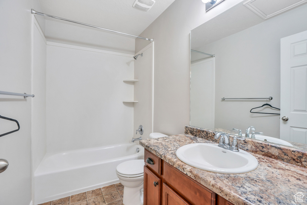 Full bathroom featuring large vanity, shower / tub combination, toilet, and tile floors