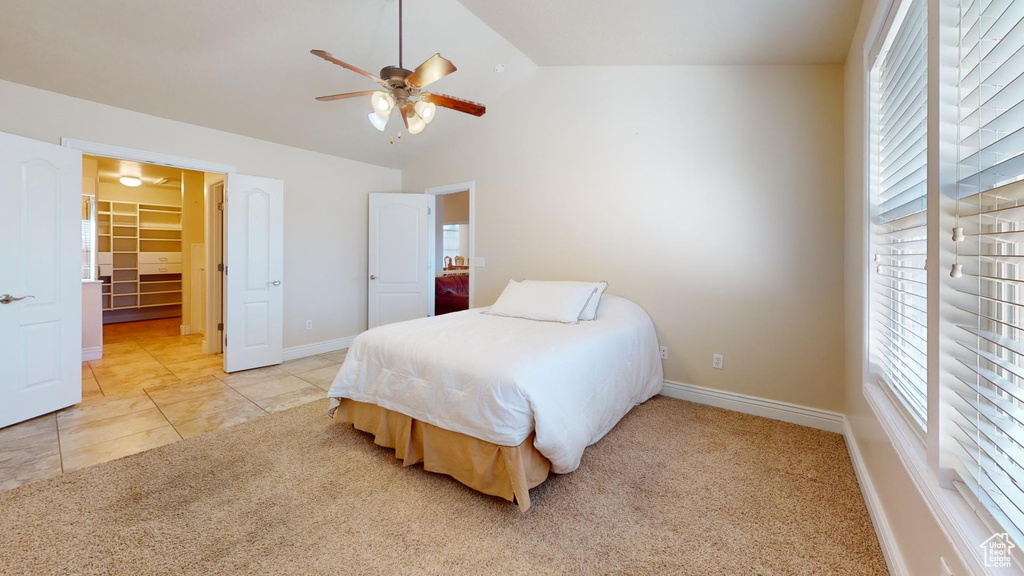 Bedroom featuring light tile flooring, vaulted ceiling, and ceiling fan