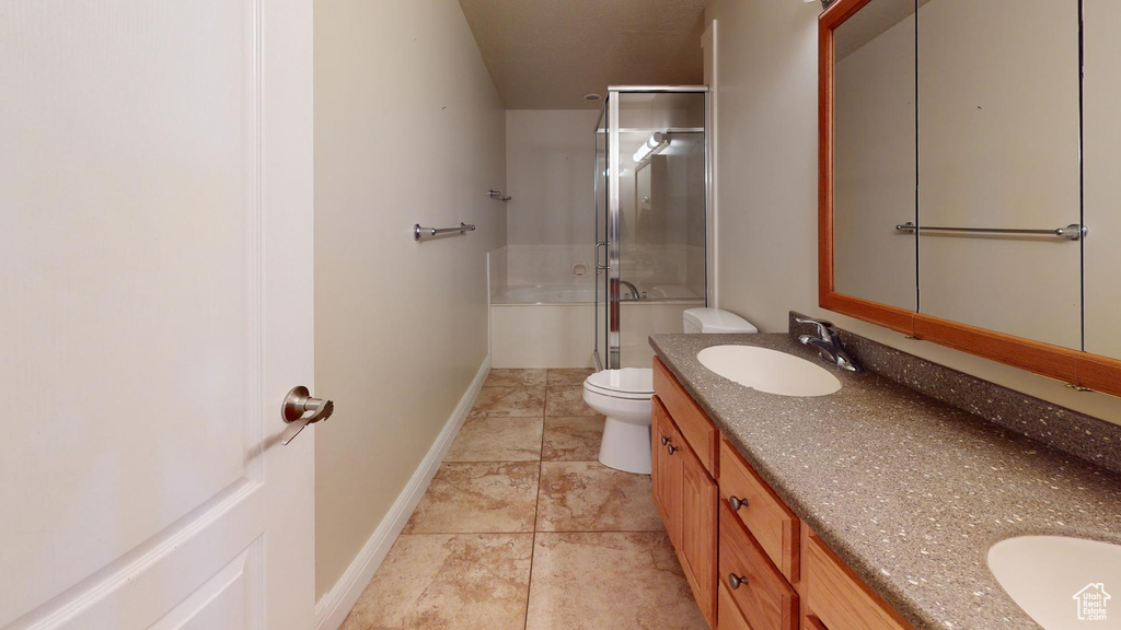 Bathroom featuring tile flooring, double sink, large vanity, and toilet
