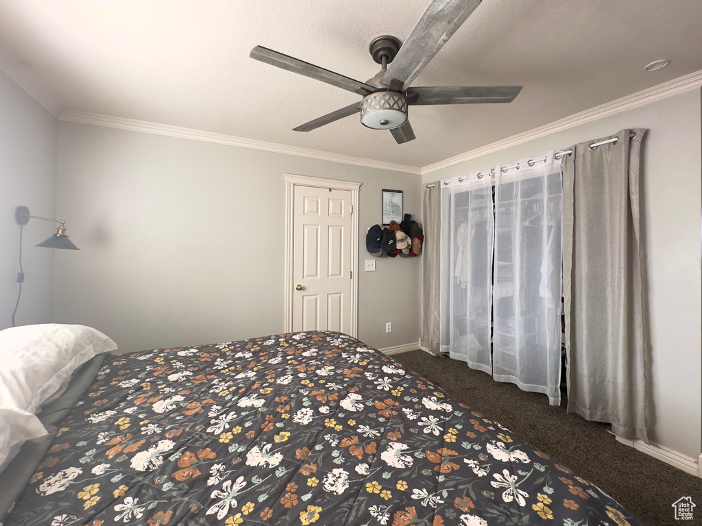 Bedroom featuring dark carpet, crown molding, a closet, and ceiling fan