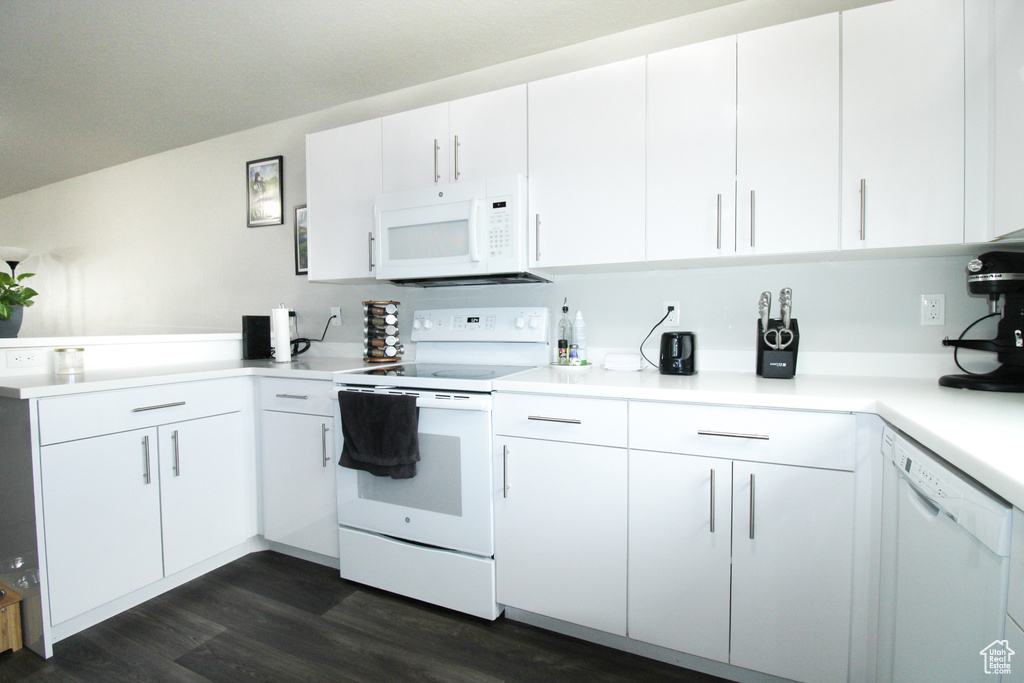 Kitchen with white cabinets, white appliances, and dark wood-type flooring