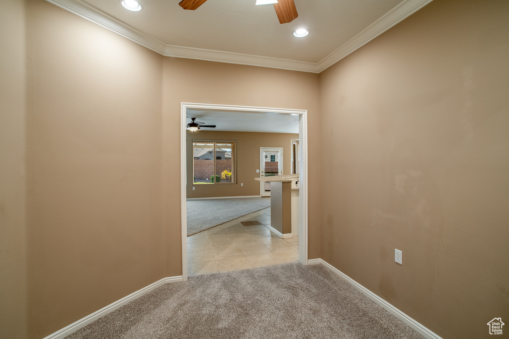 Corridor featuring light tile floors and ornamental molding