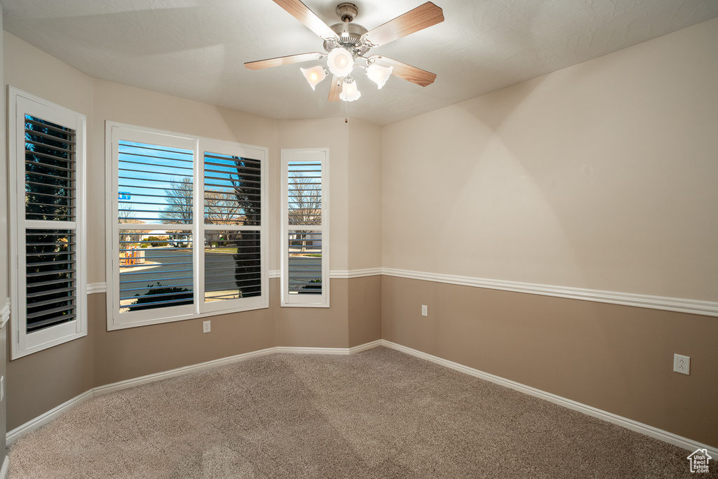 Empty room with carpet floors and ceiling fan