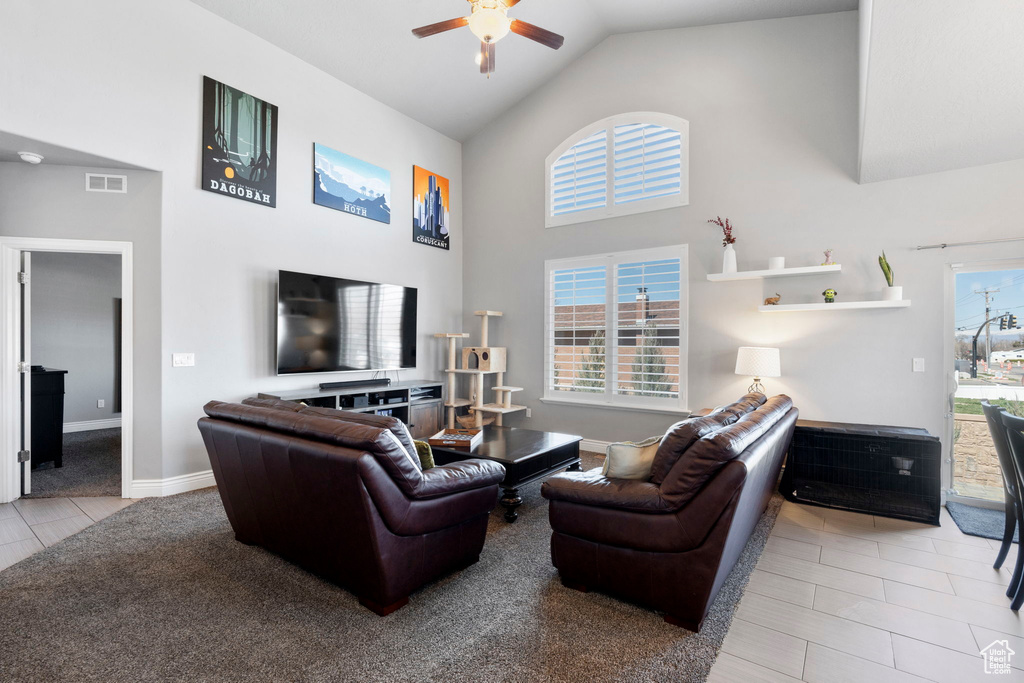 Living room featuring high vaulted ceiling, a wealth of natural light, ceiling fan, and light tile floors