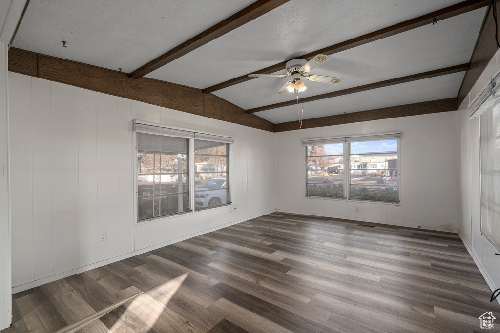 Unfurnished room with lofted ceiling with beams, dark hardwood / wood-style floors, and ceiling fan