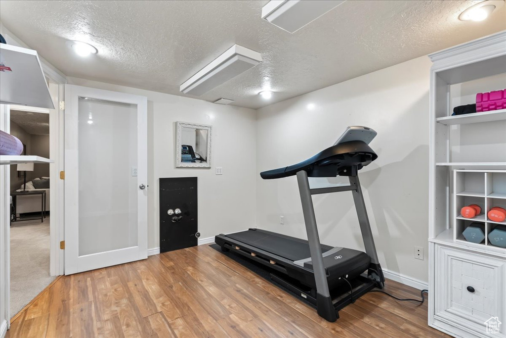 Workout area featuring light carpet and a textured ceiling