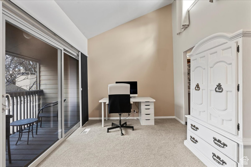 Office area featuring vaulted ceiling and light colored carpet