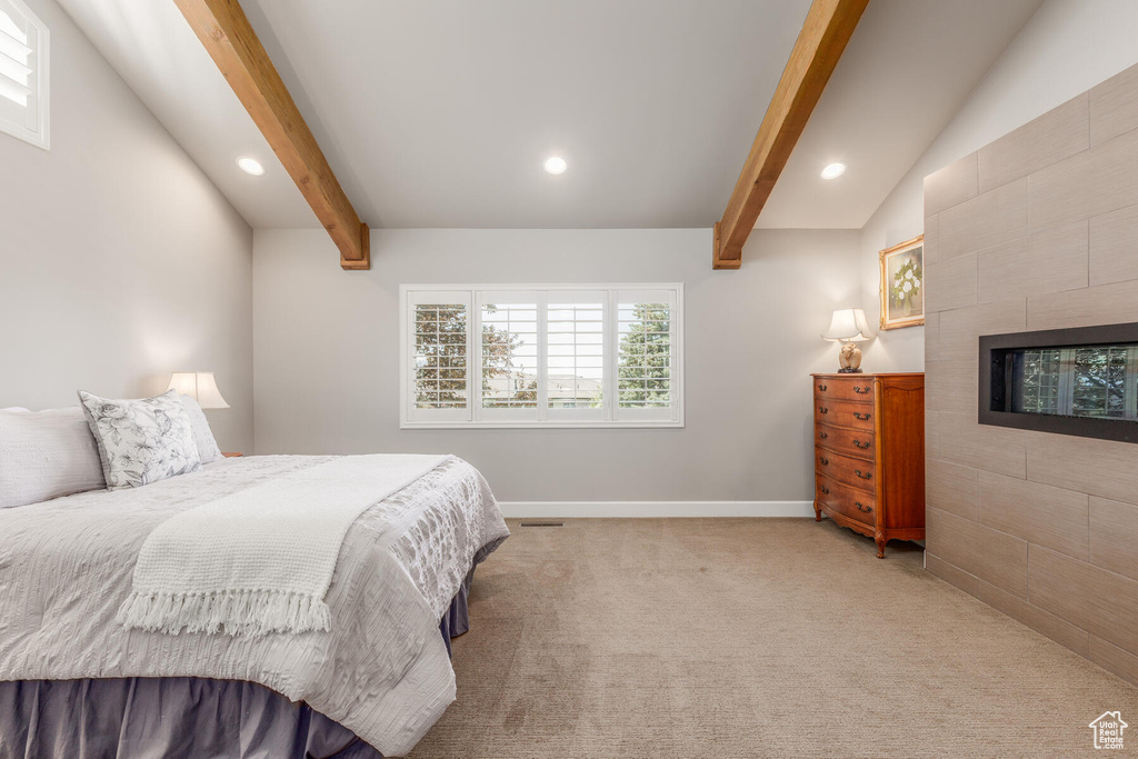 Bedroom featuring vaulted ceiling with beams and carpet flooring