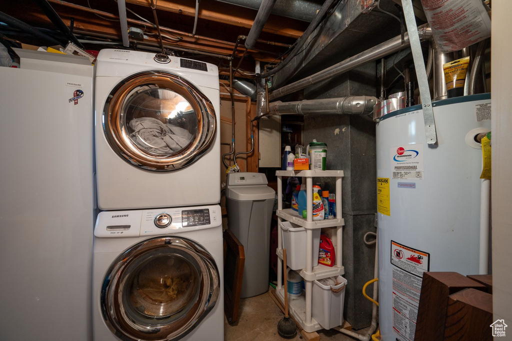 Laundry room with stacked washer and clothes dryer and water heater