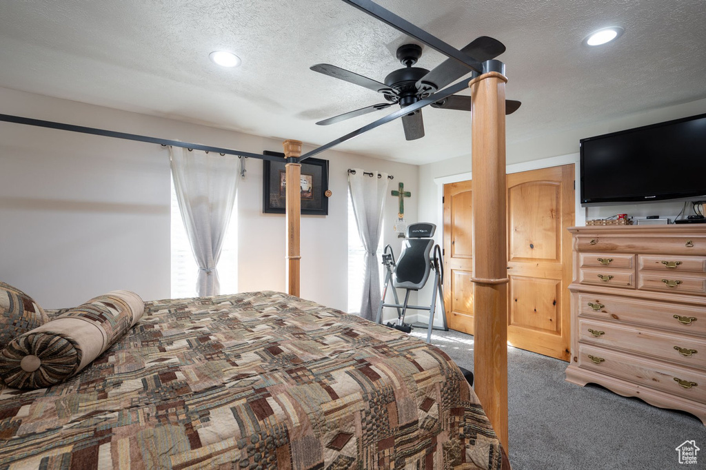 Bedroom with carpet floors, a textured ceiling, and ceiling fan