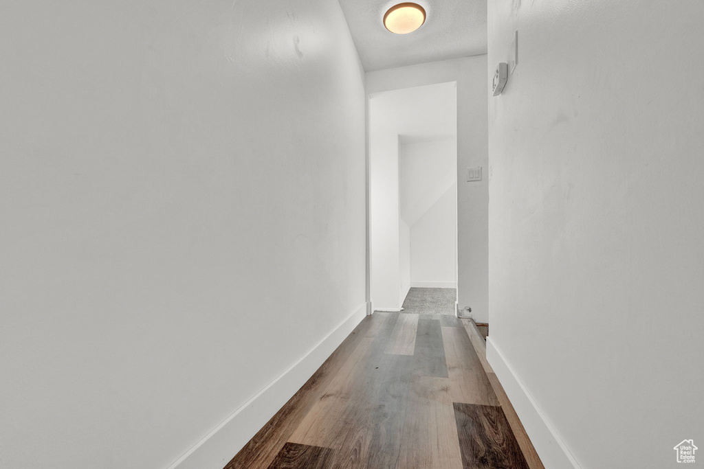Corridor with hardwood / wood-style floors