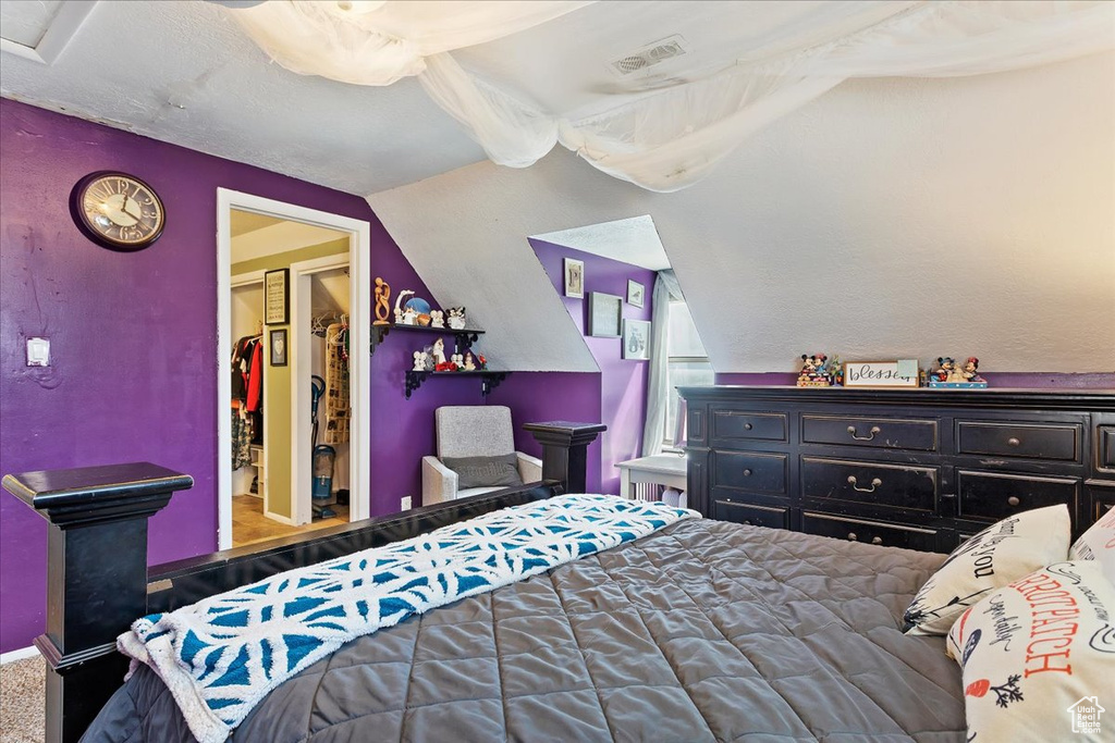 Bedroom with a spacious closet and lofted ceiling