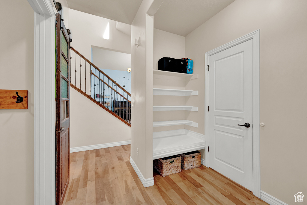 Stairs featuring a barn door and light hardwood / wood-style floors