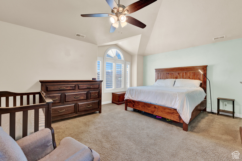 Bedroom featuring vaulted ceiling, light carpet, and ceiling fan