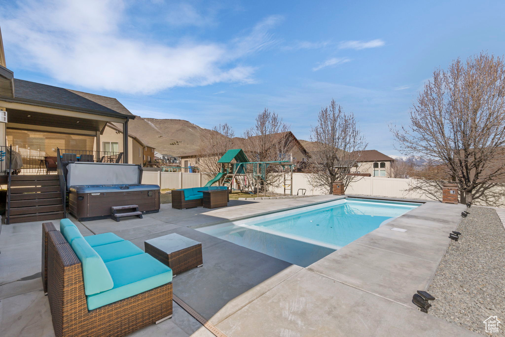 View of pool with a patio and a hot tub