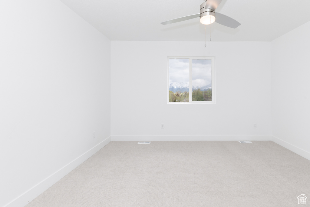 Spare room featuring ceiling fan and carpet