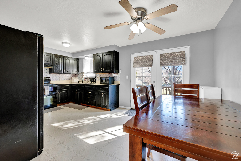 Kitchen with black appliances, ceiling fan, french doors, light tile floors, and backsplash