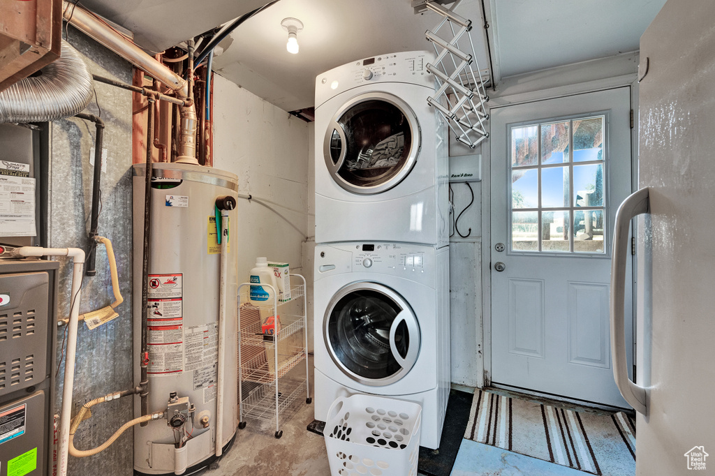 Laundry area with gas water heater and stacked washer / dryer