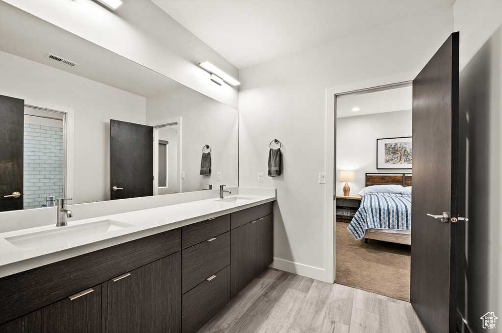 Bathroom featuring double sink, hardwood / wood-style flooring, and oversized vanity