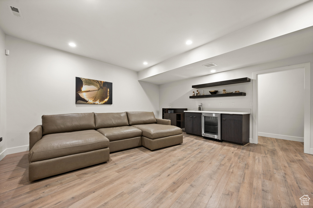 Living room with light hardwood / wood-style flooring, wine cooler, and bar area