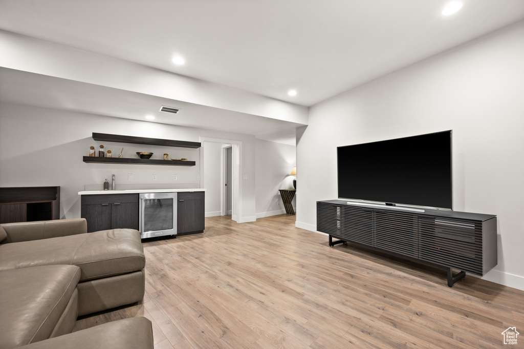 Living room featuring bar, light hardwood / wood-style flooring, and wine cooler